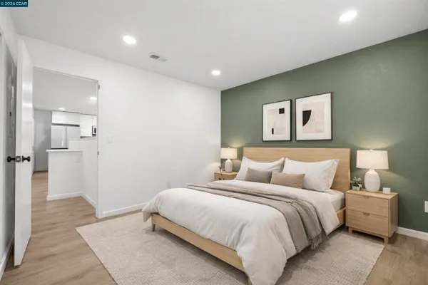 a bedroom with a bed and painting on the wall