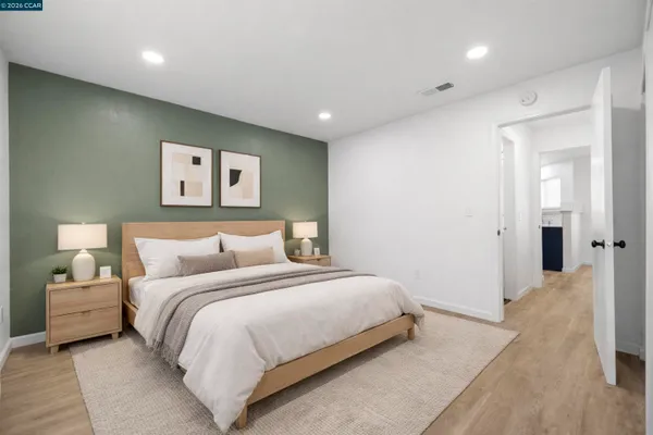 a bedroom with a bed and painting on the wall