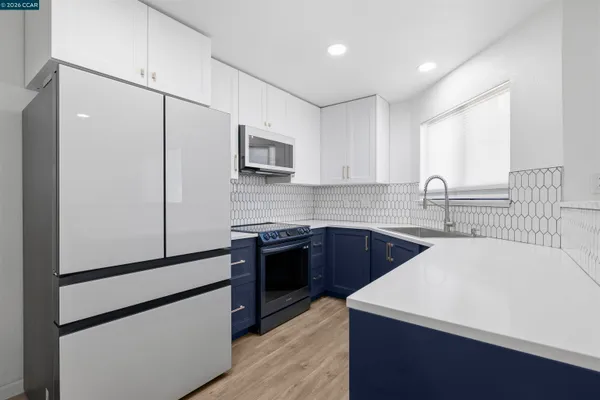 a kitchen with stainless steel appliances a sink stove and refrigerator