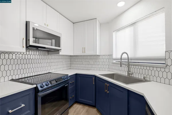 a kitchen with a sink stove and microwave