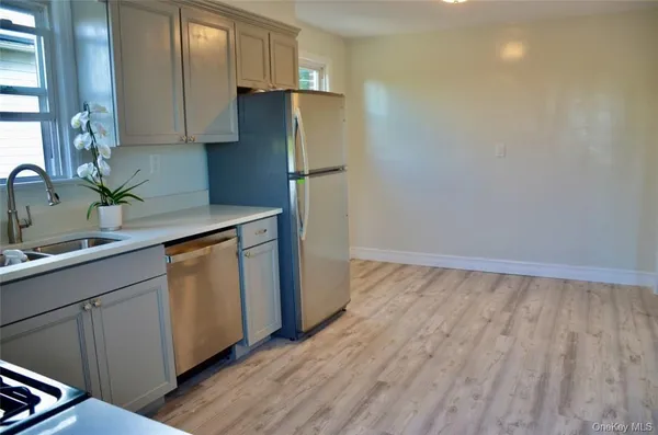 a kitchen with granite countertop a refrigerator and a sink