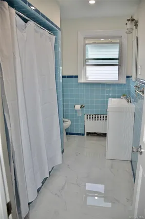 a bathroom with a sink a toilet and a window