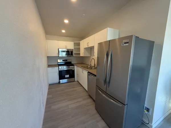 a large kitchen with a refrigerator and a sink
