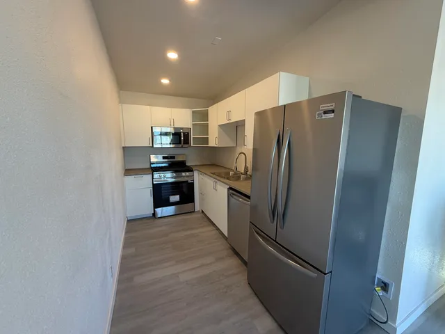 a large kitchen with a refrigerator and a sink