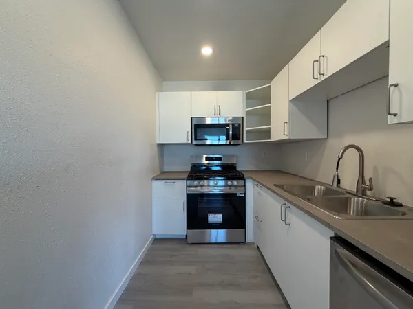 a kitchen with stainless steel appliances granite countertop a sink and a stove