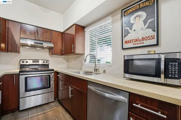 a kitchen with stainless steel appliances a stove microwave and sink