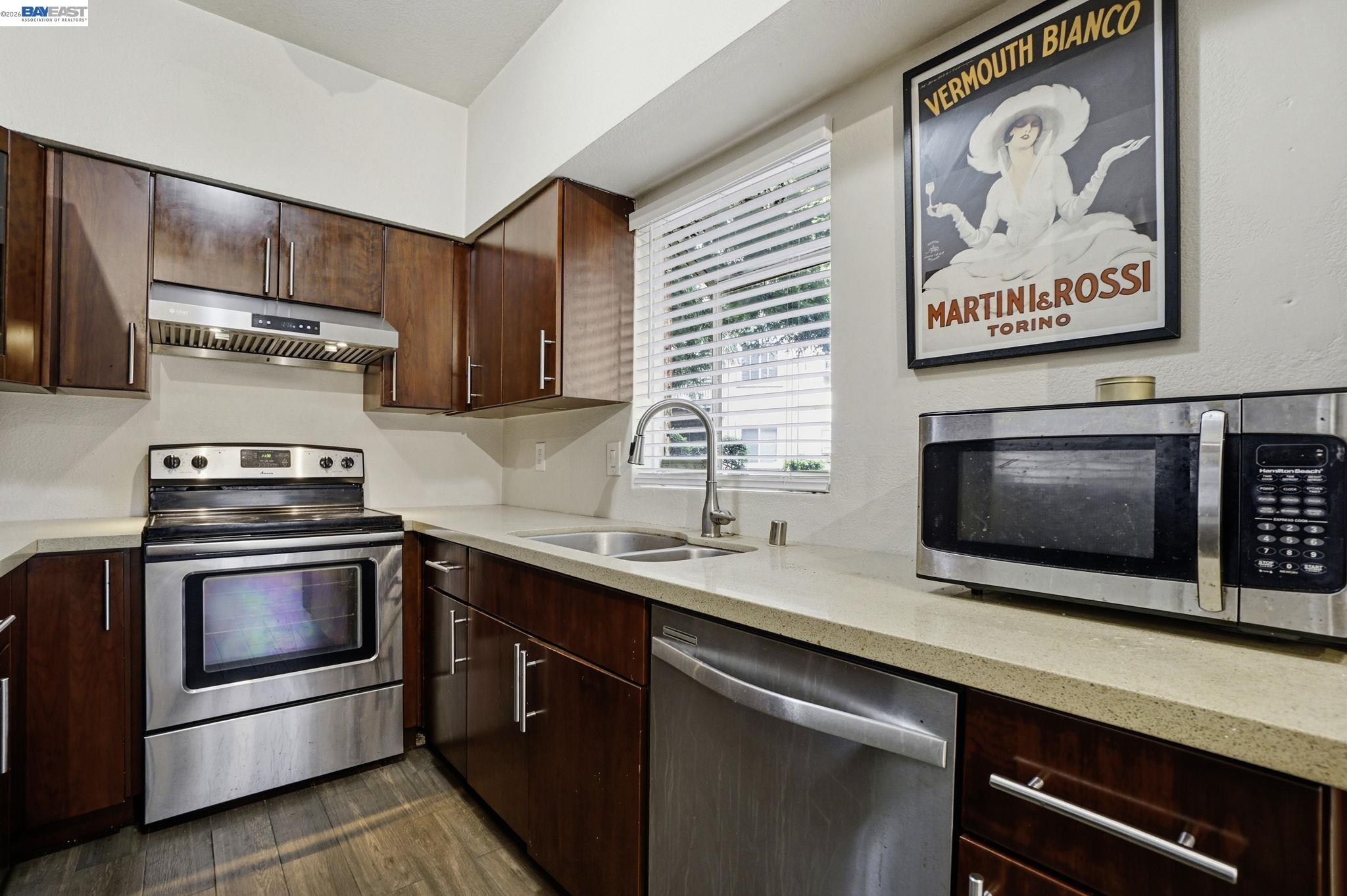 1405 Forest Run Hercules, CA 94547 - Photo 11 of 26 a kitchen with stainless steel appliances a stove microwave and sink