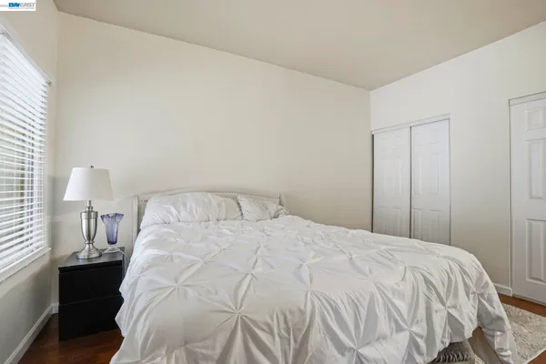 a large bed sitting in a bedroom next to a lamp