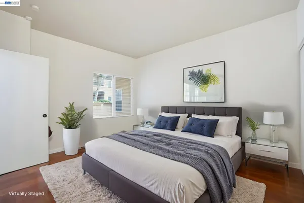 a bedroom with a balcony a bed and a painting on the wall