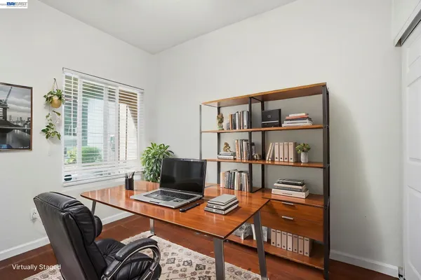 a living room with furniture a bookshelf and a window