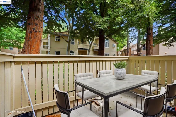 a view of a patio with table and chairs and wooden fence