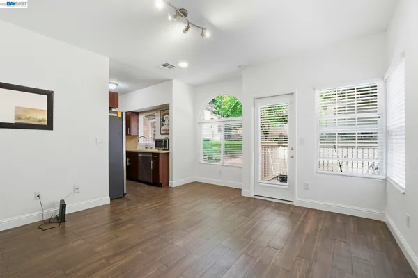 a view of an empty room with a window and wooden floor