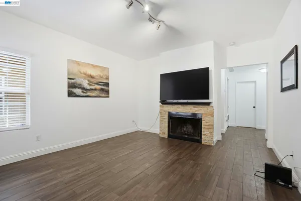 an empty room with furniture fireplace and wooden floor