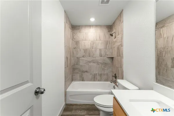 a bathroom with a toilet a sink and bathtub