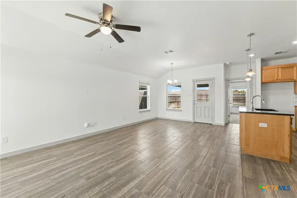 a view of a kitchen with wooden floor and a ceiling fan