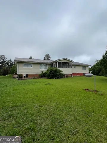 a sign board with lawn chairs next to yard