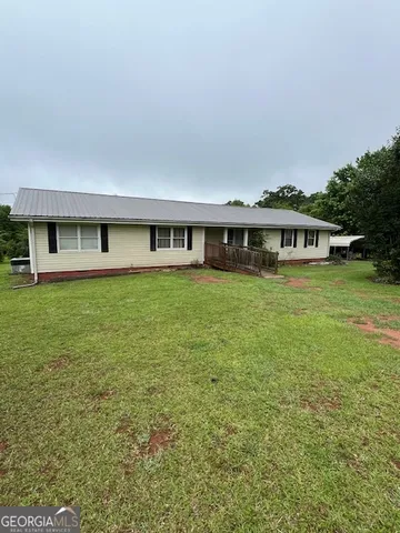 a view of a house with yard and sitting area