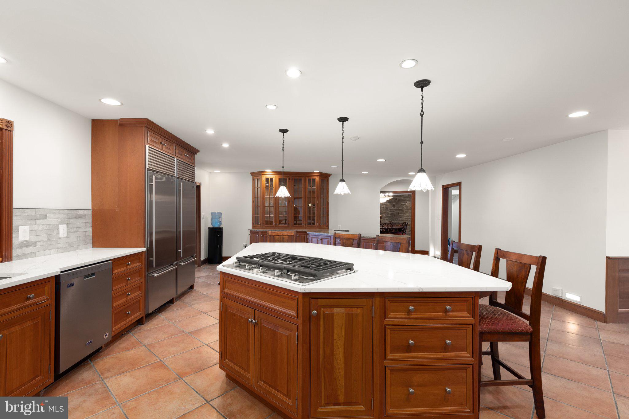 10810 Baronet Road Owings Mills, MD 21117 - Photo 33 of 83 a kitchen with a stove a kitchen island a sink cabinets and wooden floor