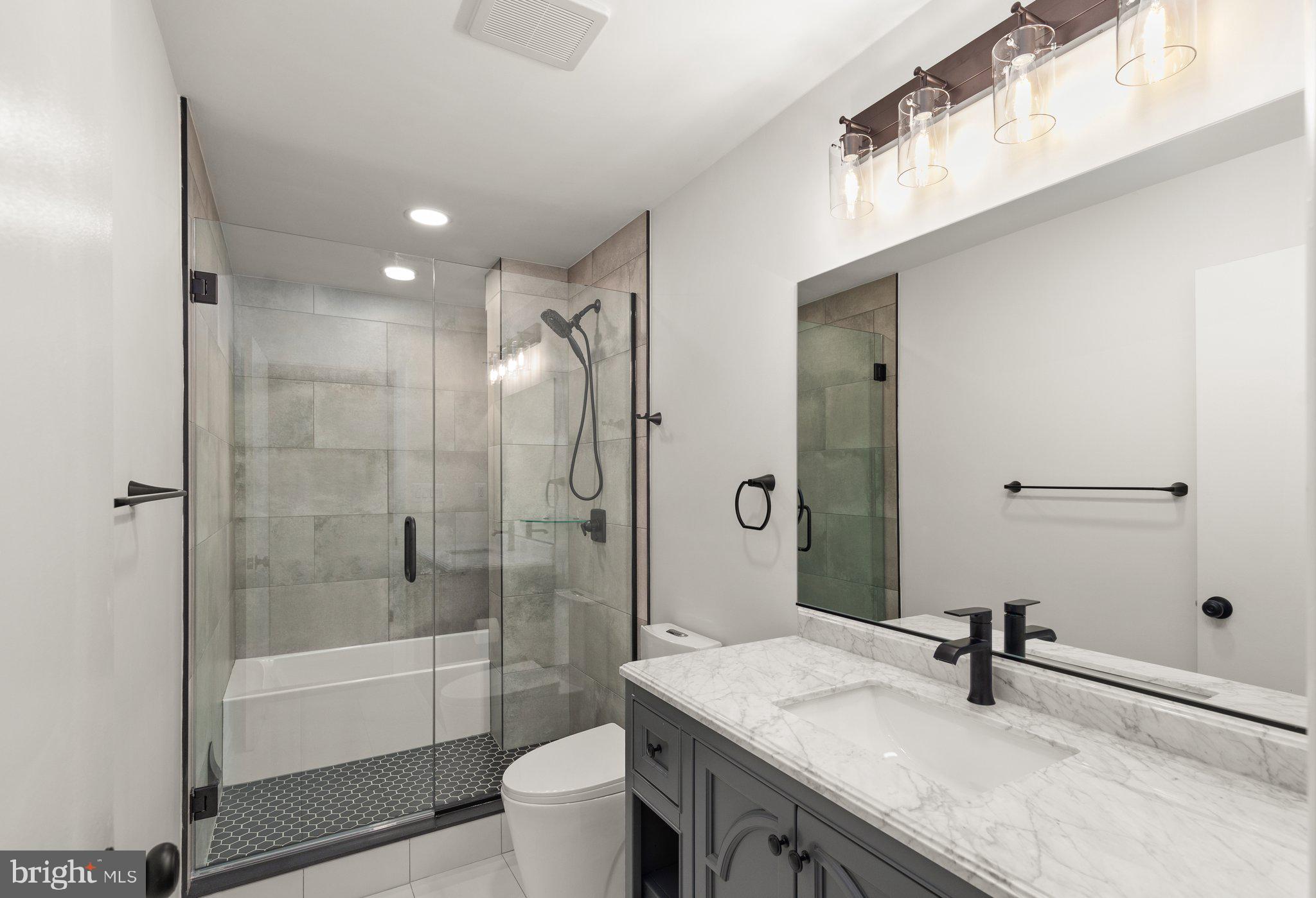 10810 Baronet Road Owings Mills, MD 21117 - Photo 46 of 83 a bathroom with a granite countertop sink a toilet and shower