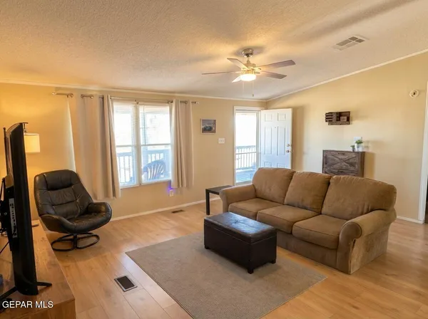 a living room with a bed furniture and a flat screen tv