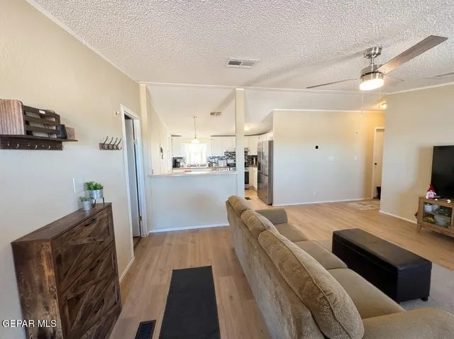 a view of a livingroom with furniture a flat screen tv and wooden floor