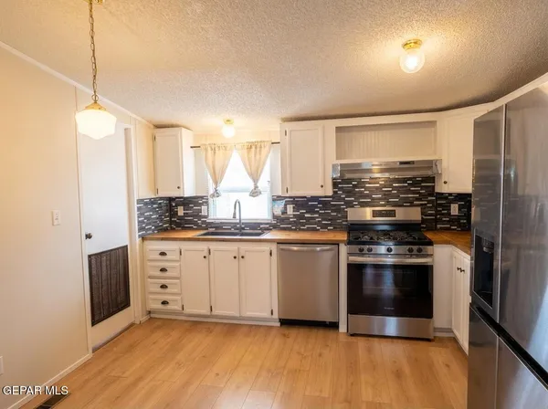 a kitchen with granite countertop white cabinets and white appliances