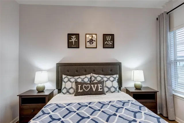 a bedroom with a bed and a lamp on dresser