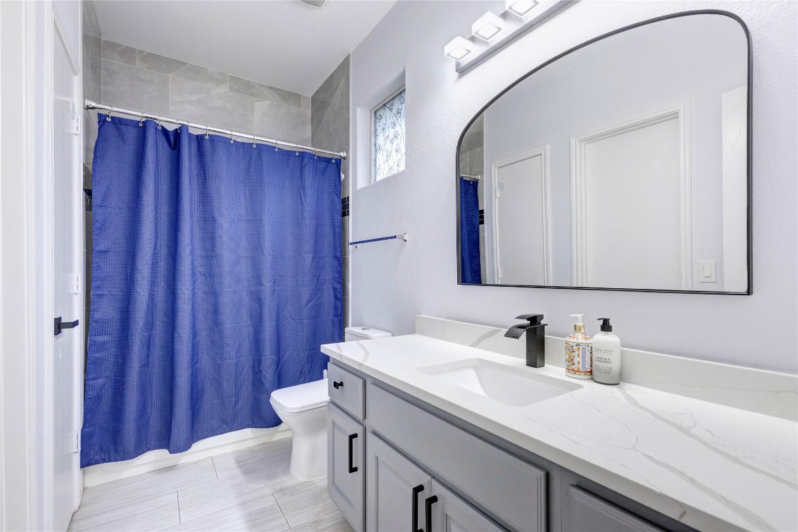 7510 Lazy Creek Drive, Unit B Austin, TX 78724 - Photo 28 of 36 a bathroom with a sink a toilet and mirror