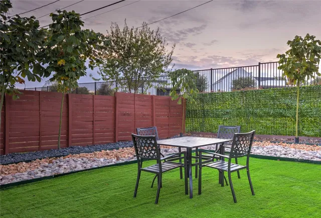 a view of a chairs and table in backyard of the house
