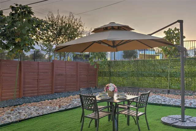 a view of a chair and table in backyard