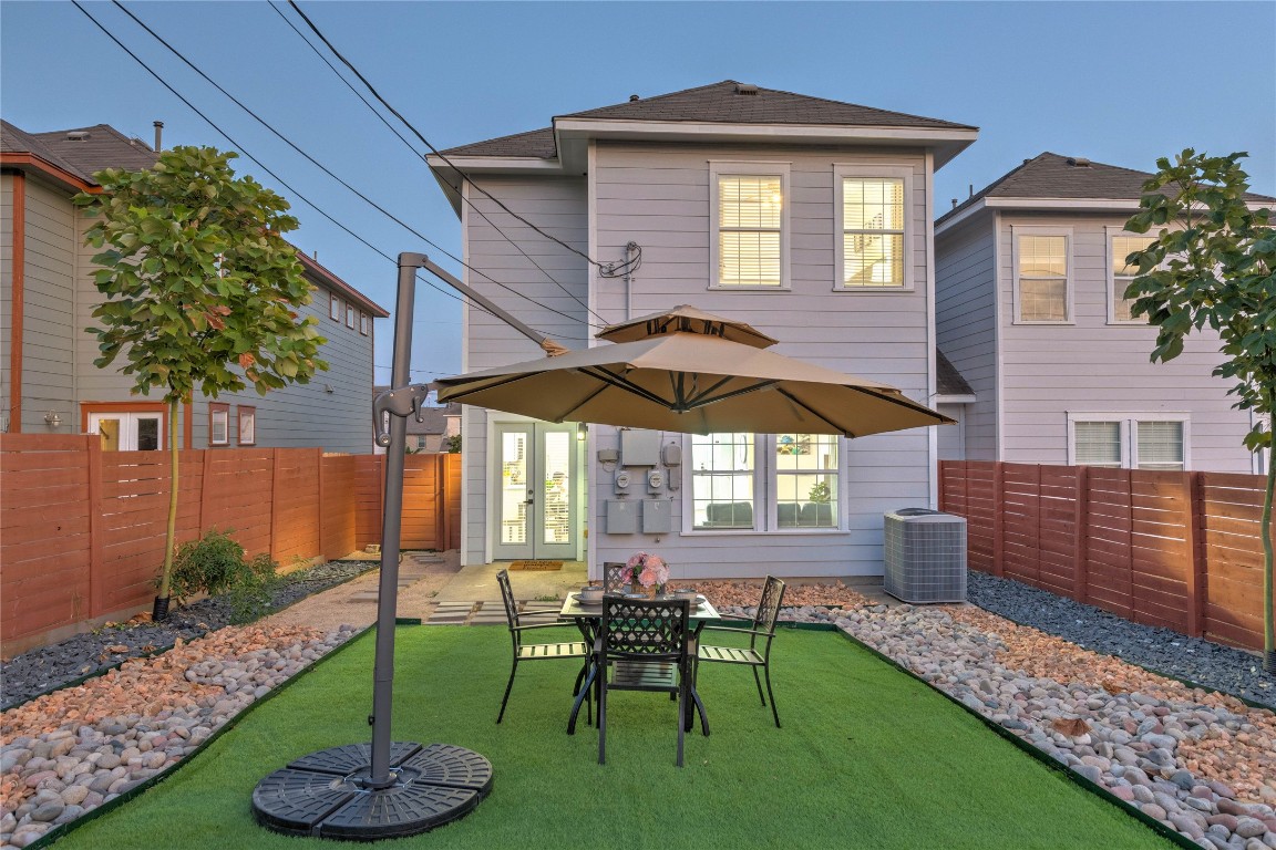 7510 Lazy Creek Drive, Unit B Austin, TX 78724 - Photo 35 of 36 a view of backyard with table and chairs under an umbrella