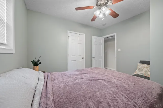 a view of a white house with large windows and a small yard