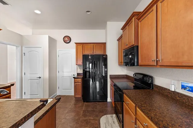 a kitchen with stainless steel appliances granite countertop a refrigerator a stove and a sink with wooden floor