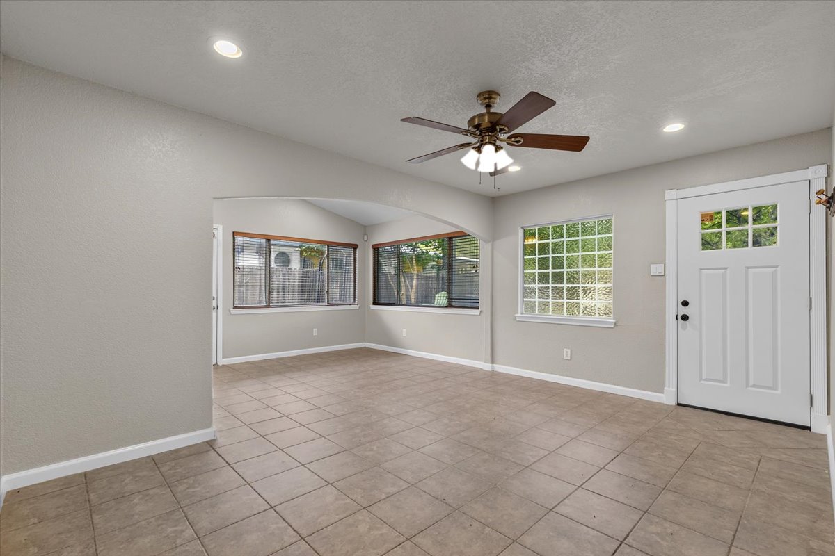7604 Robalo Road Austin, TX 78757 - Photo 12 of 36 A welcoming entryway with tile flooring transitions smoothly into an open living area, illuminated by recessed lighting and a ceiling fan.