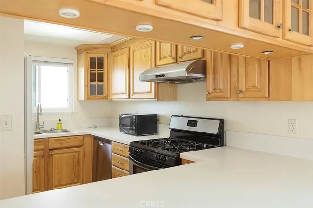 a kitchen with stainless steel appliances a stove a sink a refrigerator and cabinets