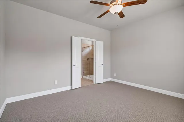 an empty room with chandelier fan