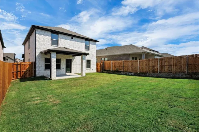 a view of a house with a yard and wooden fence