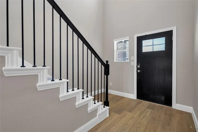an entryway with wooden floor and stairs
