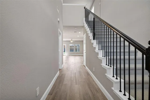 a view of a hallway with wooden floor and staircase