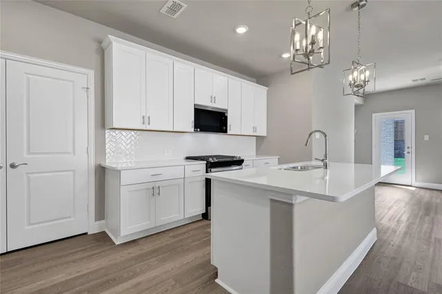 a kitchen with a sink appliances and cabinets