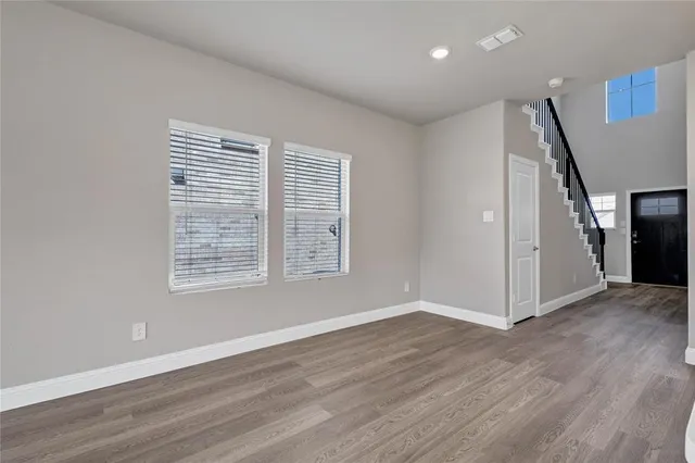 an empty room with wooden floor and entrance
