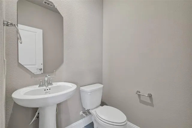 a bathroom with a sink a toilet and mirror