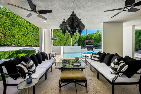 a living room with patio furniture and a potted plants