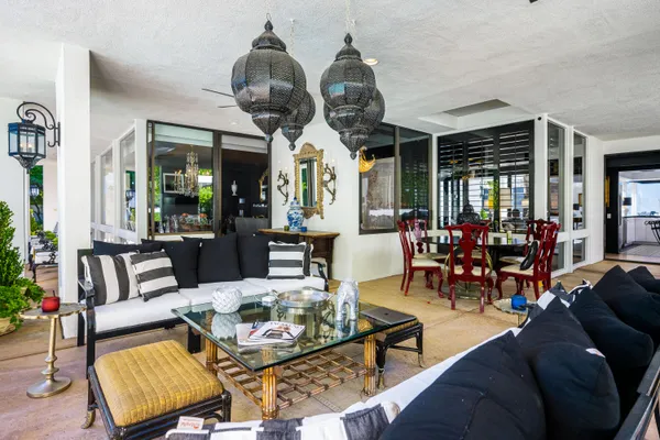 a living room with furniture a chandelier and a large window