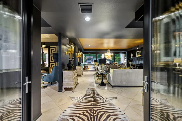 a living room with couches and a dining table with a large kitchen view