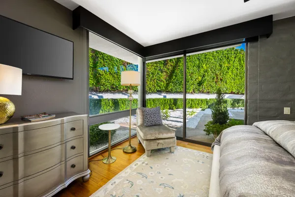 a bedroom with furniture and large windows