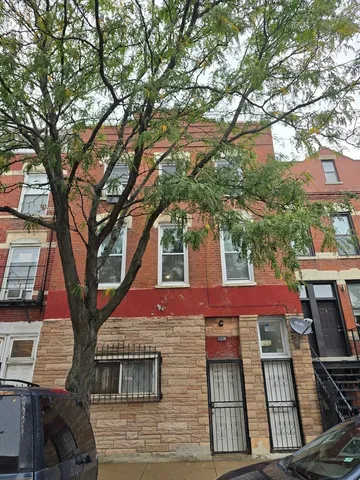 a front view of a house with a tree