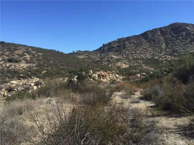 a view of a dry yard with mountains in the background