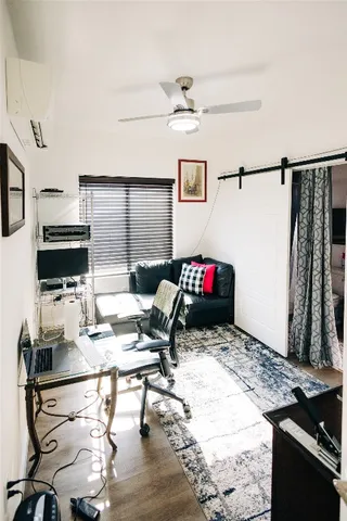 a work room with furniture a flat screen tv and a window