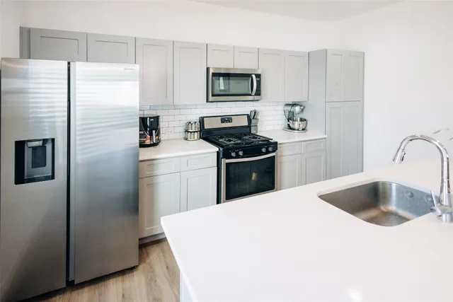 a kitchen with a table chairs refrigerator and microwave